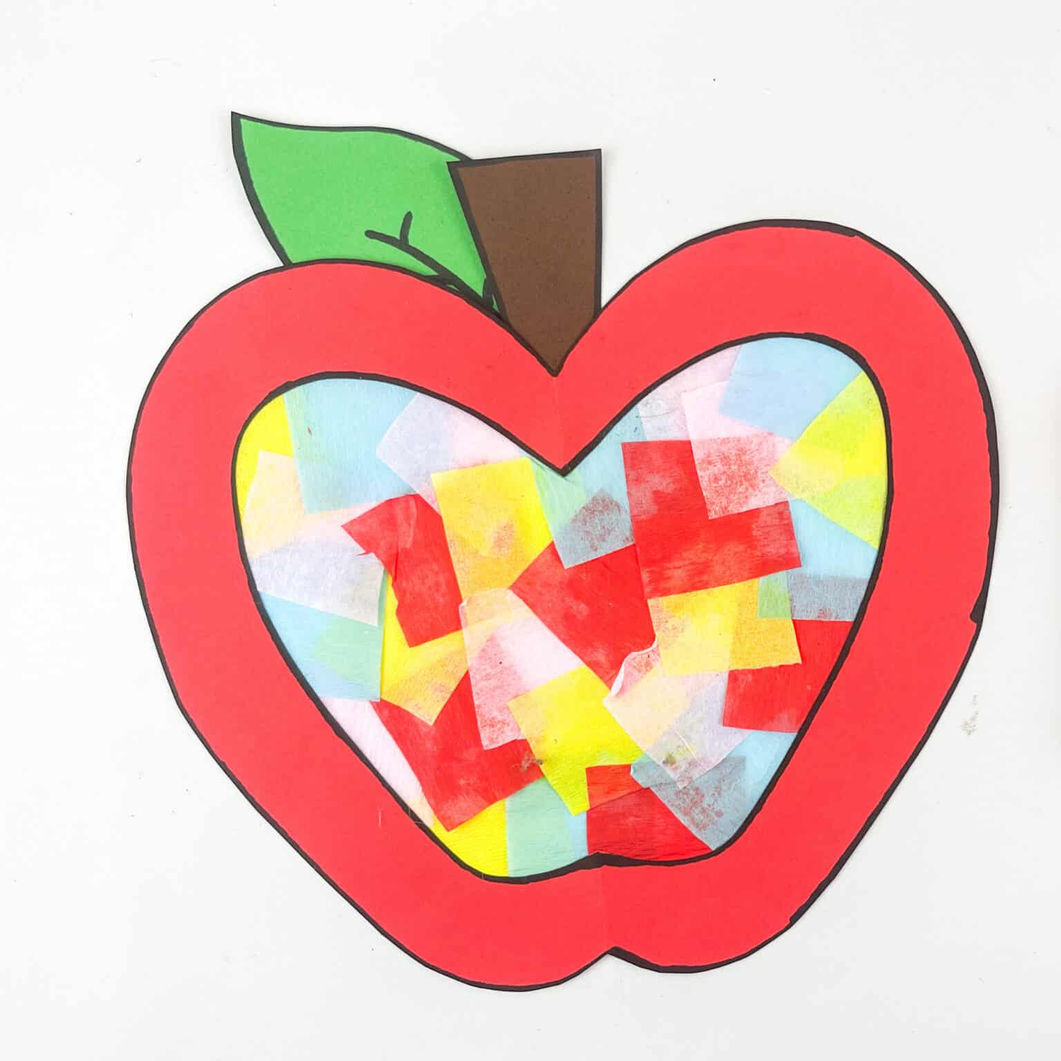 Apple suncatcher craft made with construction paper, tissue paper, and tape.